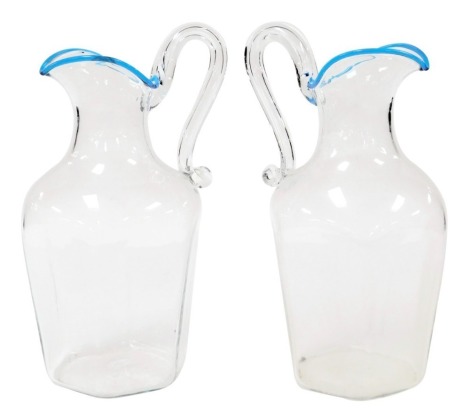 A pair of 20thC cut glass water jugs, of hexagonal form, with a scrolling handle and blue trimmed lip, etched marks for Murano, 24cm high.