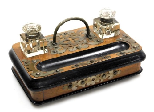 A Victorian walnut and ebonised desk stand, with brass mounts and cut glass inkwells, with a frieze drawer, raised on bun feet, 25cm wide.