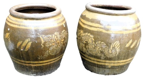 A pair of Chinese brown glazed stoneware barrel planters, decorated with a band of dragons, 46cm high.