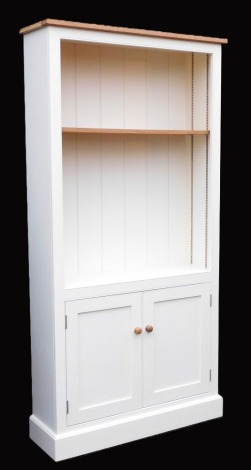 A light oak pine and grey painted cupboard bookcase, with a single shelf, over a pair of cupboard doors, raised on a plinth base, 200.5cm high, 100cm wide, 30cm deep.