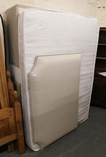 A double bed, comprising upholstered headboard in grey with stud work, divan base and mattress.