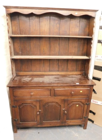 An oak stained dresser, with plate rack over base unit of two drawers over three panelled doors, raised on square supports. (1)