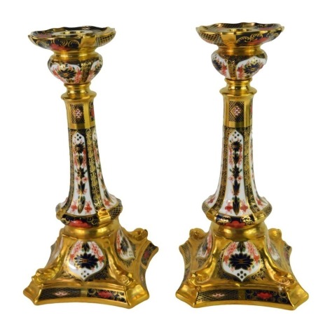 A pair of Royal Crown Derby Old Imari porcelain candlesticks, gold ground, pattern 1128, printed marks, 27cm high, boxed.