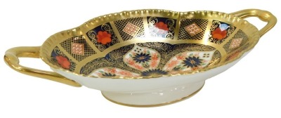 A Royal Crown Derby Old Imari porcelain twin handled oval pedestal sweetmeat dish, gold ground, pattern 1128, red printed marks, 22cm wide, boxed.