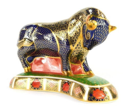 A Royal Crown Derby porcelain paperweight, modelled as a bull, gold stopper and red printed marks, 14cm high, 20cm wide, boxed.