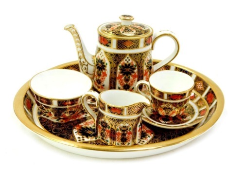 A Royal Crown Derby Old Imari porcelain miniature tea service, pattern 1128, comprising oval tray, 19.5cm diameter, teapot, sugar bowl, milk jug and tea cup and saucer.