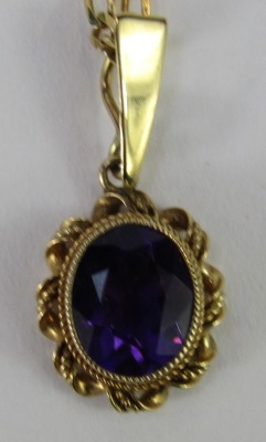 An amethyst pendant and chain, the oval amethyst pendant in a rope twist border, 2.5cm high, on a byzantine link neck chain, 40cm long, stamped 9kt, 5g all in. - 2