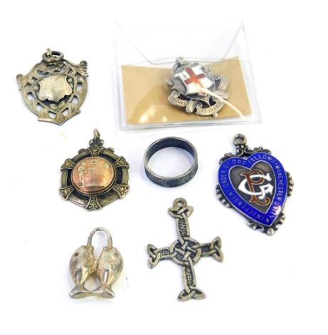 Silver wares, comprising four silver crests, two enamel set, a white metal two mounted fish pendant, unmarked, a crucifix stamped silver, and a hammered dress ring, white metal unmarked, 50g all in.