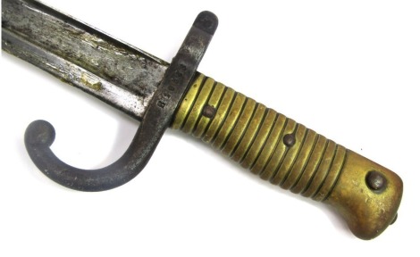 An 1866 pattern French Chassepot sword bayonet, with brass grip, and black painted metal scabbard, numbered B10588, length of blade 57cm.