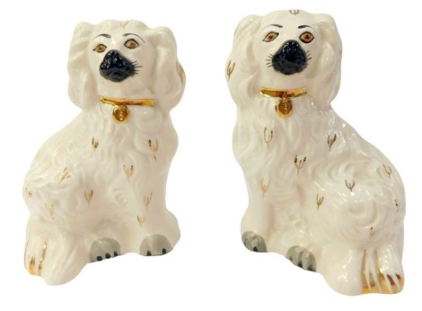 A pair of Royal Doulton pottery figures, modelled as spaniels, in cream with gilt highlights, printed marks, 14cm high.