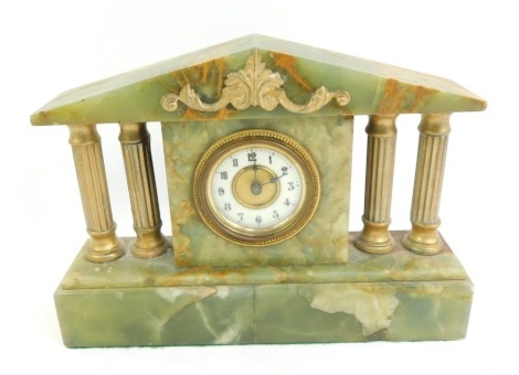 An early 20thC onyx mantel clock, the brass dial with white enamel chapter ring bearing Arabic numerals, key wind, the case of architectural form, with gilt painted columns and square base, 17cm high.