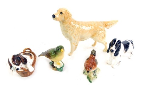 A group of animal figures, comprising a Beswick Labrador, printed marks, 14cm high, a Royal Doulton Springer Spaniel, 9cm high, a Royal Doulton dog in basket, and two Beswick birds comprising Green Finch and Wren.