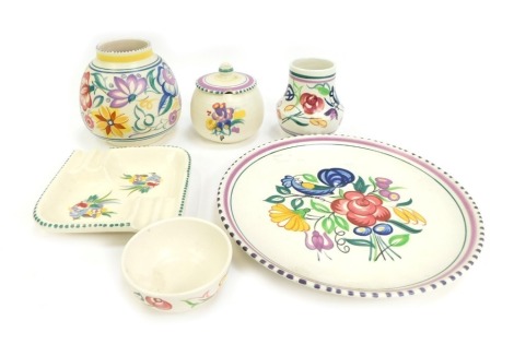 A group of Poole pottery, traditionally decorated with floral sprays, to include condiment pot and cover, 9cm high, ashtray, 13cm wide, plate, 24cm diameter, etc.