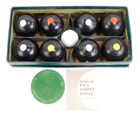 A set of Bias Banda carpet bowls, comprising eight black bowls, with smaller white ball, and red plastic circular mat, in fitted box, with rules.