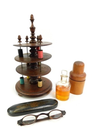 An early 20thC turned mahogany reel stand, with three tiers, on circular base with compressed wooden feet, 27cm high (AF), together with a Victorian boxwood scent bottle container, by G Mann, the screw top enclosing a glass bottle with contents, 11.5cm hi