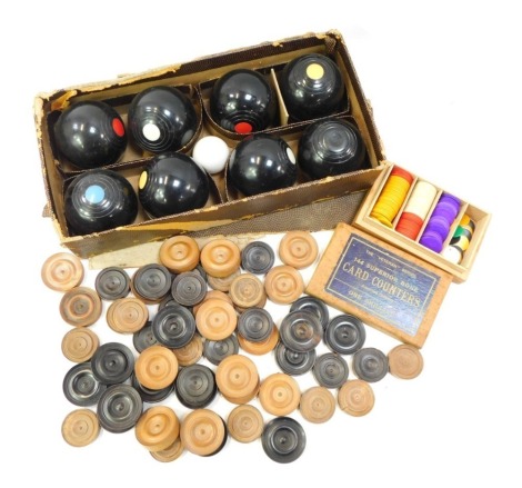 A Banda carpet bowls set, boxed, together with various turned boxwood draughts counters, and a boxed set of Veteran Series coloured bone card counters.