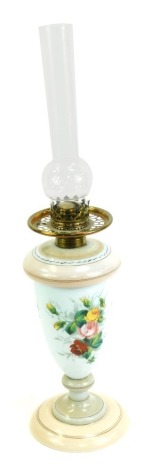 A Victorian milk glass oil lamp, with glass chimney, the base decorated with flowers against an opaque white ground, blush pink circular base, 63cm high overall, lacking shade.