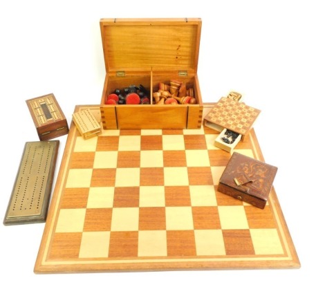 A 20thC chess board, together with a treen box containing various chess pieces, the board 50cm x 50cm, together with various cribbage boards, etc. (a quantity)