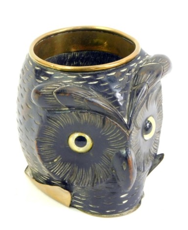 A 19thC ebony and brass owl cup, with brass rim and foot, the carved face with inset glass eyes, 9.5cm high, 6.5cm diameter.