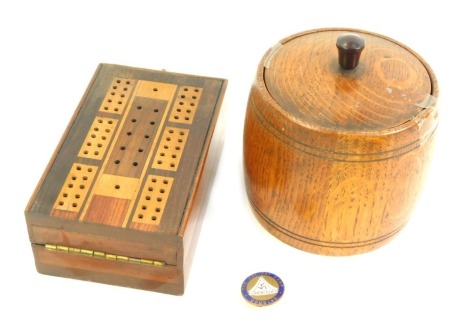 An early 20thC oak tea caddy, 14cm high, and a boxwood draughts board, 13cm wide, together with a Holiday Camp Douglas pin. (3)