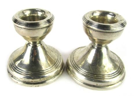 A pair of George V silver dwarf candlesticks, each with a reeded design on a weighted base, Birmingham 1917, 6cm high. (2)