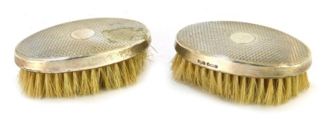 A pair of Edward VI silver backed hair brushes, with engine turned decoration, circular vacant reserve, Birmingham 1902.