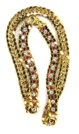 A gold fracture filled ruby and cubic zirconia necklace, with a row of alternating round mixed cut fracture filled rubies and cubic zirconias, six claw set to plain collets, with foliate link eight side, to chased end caps and a side lever clasp, tested a