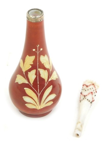 An early 20thC milk glass bud vase, painted with flowers against a red ground, with silver collar, together with a Victorian opaline glass cheroot holder, 16cm high. (2)