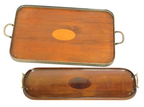 Two Edwardian trays, comprising a mahogany and satin wood inlaid rectangular tray, with silver plated gallery and twin handles, 69cm wide, 35cm deep, and an early 20thC oval mahogany boxwood line inlaid tray with brass handles, 59cm long, 19cm deep. (2)