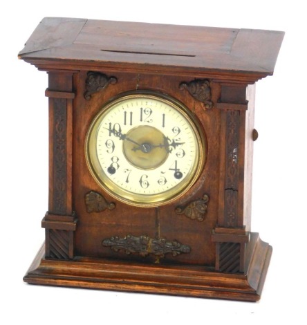 A late 19thC Continental oak cased mantel clock, circular brass dial with enamel chapter ring bearing Arabic numerals, eight day movement with coil strike, the case of architectural form, with applied carving, 30cm high, 30cm wide, 17cm deep.