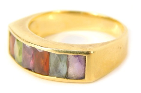 A half hoop dress ring, the panel set with six multicoloured rectangular cut stones, with a tiny diamond star set to border, on a yellow metal band stamped 750, ring size M½, 5.2g all in.