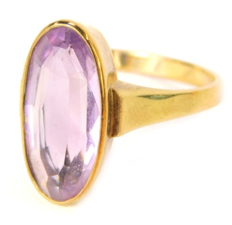 An amethyst dress ring, the oval amethyst in a rub over setting, on a yellow metal band stamped 333, ring size O, 3.3g all in.