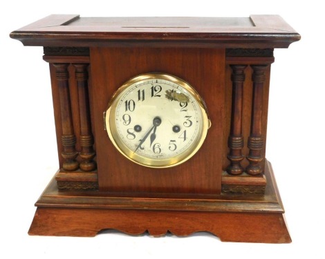 A mid 20thC stained mahogany and pine cased mantel clock, the silvered dial bearing Arabic numerals, eight day movement with coil strike, the case of architectural form, 28cm high, 33cm wide, 15cm deep.