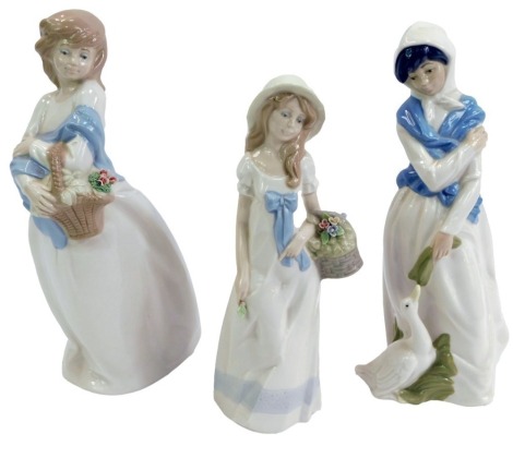 Three Spanish porcelain figures, comprising a Diana figure of a lady carrying a basket of flowers, 30cm high, a Diana figure of a lady feeding a goose, 28cm high, and a Nadal figure of a girl carrying a basket of flowers, 24cm high. (3)