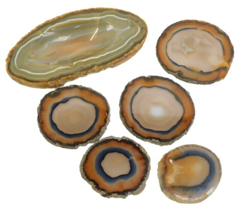 Six agate wares, comprising three large coasters, 10cm wide, two smaller coasters, 7cm wide, and a dipped ashtray, 9cm wide.