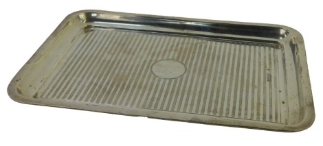 A George V silver dressing table tray, of rectangular section, with engine turned striped decoration and vacant circular cartouche, London 1919, 14.94oz.