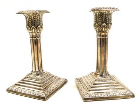 A pair of Victorian silver loaded candlesticks, with a double acanthus leaf capital and fluted column, raised on a stepped square base, Hawksworth Eyre & Co Ltd, Sheffield 1900, 15cm high.