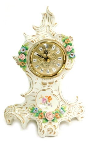 A Sitzendorf Continental porcelain mantel clock, on a white ground, painted and encrusted with flowers, circular brass dial bearing Roman numerals, with Quartz movement, 25cm high, 18cm wide.