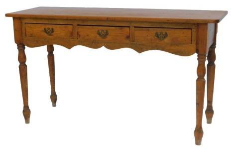 A late 19thC pine and fruitwood side table, the rectangular top above three frieze drawers, with shaped apron, on turned tapering legs, 76cm high, 134cm wide, 44cm deep.