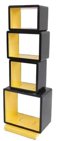 A late 20thC open shelving unit, comprising an arrangement of four recesses in yellow and black metal, on a plinth type base, 104cm high, 53cm wide, 29cm deep.