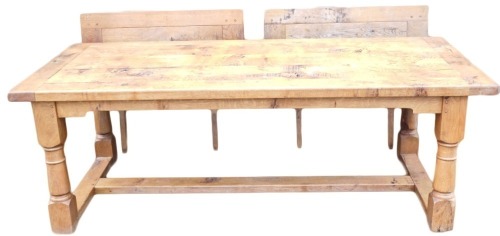 A light oak extending refectory table, with a plank top, shaped apron, on turned supports with flat H stretcher, two leaf extensions to the ends, 76cm high, 303cm long, 100cm deep.