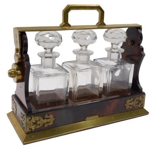 A 19thC Betjemann's Patent walnut and brass Tantalus, with four square section decanters and stoppers label to front Tiffany and Co, 35cm wide.