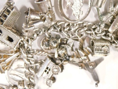 A silver charm bracelet, the curb link bracelet, with safety chain in heart shaped padlock, and various charms, to include elephant, shilling, church, horse, horse shoe, St Christopher pendant, boat, kettle, aeroplane, and others, some marked 925, others - 3