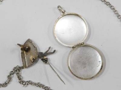 Two items of silver, comprising a silver EGD Designs ballerina brooch, on single pin back, 3cm high, and a silver floral embossed locket, 2cm high, 9.5g, and a plated chain. (3) - 2