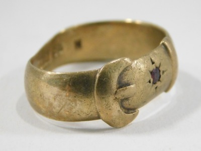 A 9ct gold buckle ring, set with one garnet and one vacant stone, maker JH, Birmingham 1909, misshapen, 4.8g all in. - 2