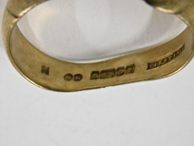 A 9ct gold buckle ring, set with one garnet and one vacant stone, maker JH, Birmingham 1909, misshapen, 4.8g all in. - 3