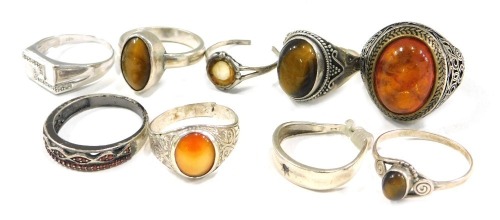 A group of white metal dress rings, to include some stone set with imitation amber, tigers eye, and others, some cut, mainly stamped 925 or 935, 49.6g all in. (9)