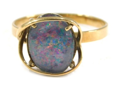 An imitation opal dress ring, the imitation opal doublet, with dark blue flare, in a raised yellow metal coloured mount, on yellow metal coloured band, believed to be gold plated, ring size W½.