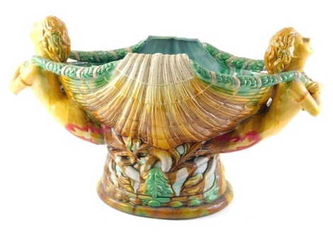 A 20thC majolica centrepiece, modelled in the form of two nude females either side of a clam shell, on an oval base, unmarked, 54cm wide.