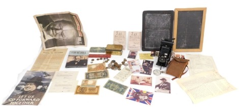 A group of early 20thC ephemera, comprising Churchill pin badges, Churchill memorabilia, WWI reproduction box set, two slate boards, a Wade and Butler razor box, boxed camera, George II and later replica bank notes, and a small group of coinage. (a quanti